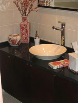 Black and white bathroom with white vessel sink and tiled backsplash